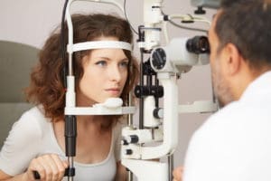 eye doctor checking the eyes of his female patient