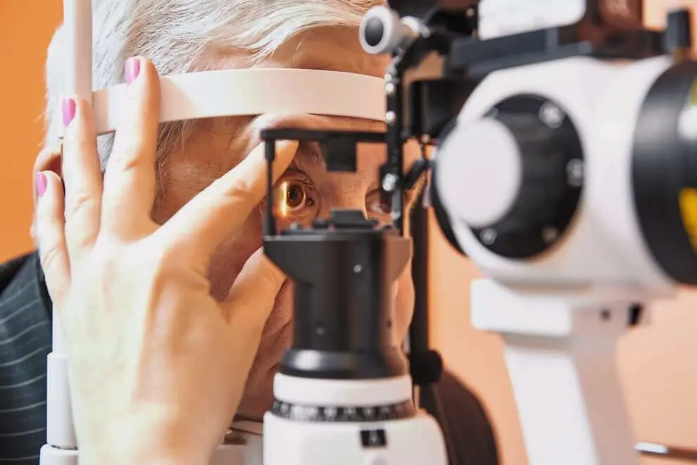A person undergoing an eye examination using a phoropter at Eye Care Clinic.