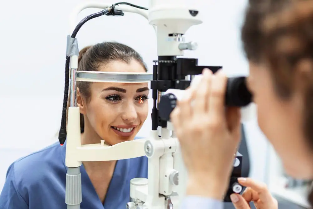 A woman undergoing an eye examination at Eye Care Clinic with an optometrist using a slit lamp.